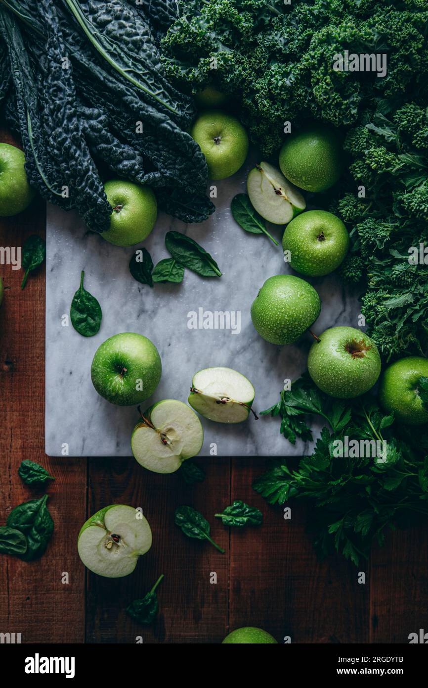 Una selezione di cibi verdi sani, tra cui mele e cavolo. Foto Stock