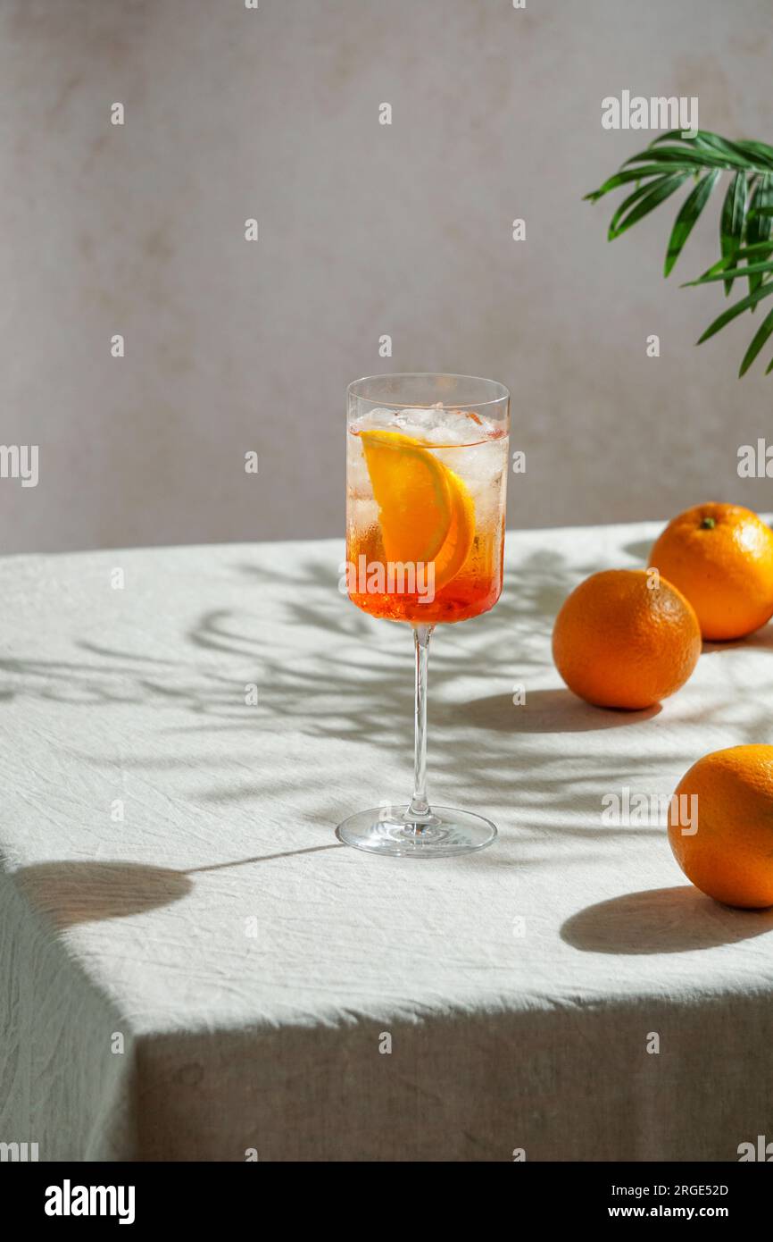 aperol spritz, cocktail, su una tovaglia di lino, ombre, luce solare intensa, drink estivo in bicchiere Foto Stock