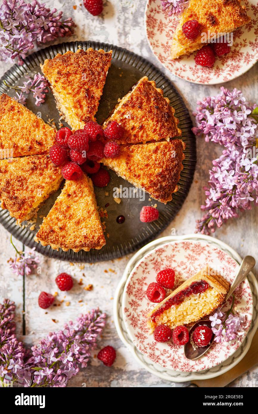 Fette di lampone e crostata essiccata al cocco servite su piatti con contorno fresco ai lamponi. Foto Stock