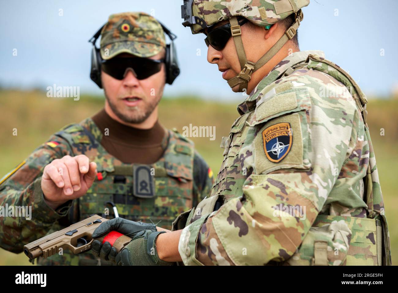 Polonia. 19 luglio 2023. Il sergente dell'esercito americano Isaac Lozamo con l'8th Engineer Battalion, assegnato alla Headquarters and Headquarters Company, 1st Battalion, 9th Cavalry Regiment, 2nd Armored Brigade Combat Team, 1st Cavalry Division, supporto 4th Infantry Division, riceve istruzioni su una pistola M17 dall'esercito tedesco OR-7 (e-7) Thomas Seidemannat Bemowo Piskie, Polonia, 18 luglio. (Immagine di credito: © U.S. Army/ZUMA Press Wire) SOLO USO EDITORIALE! Non per USO commerciale! Foto Stock