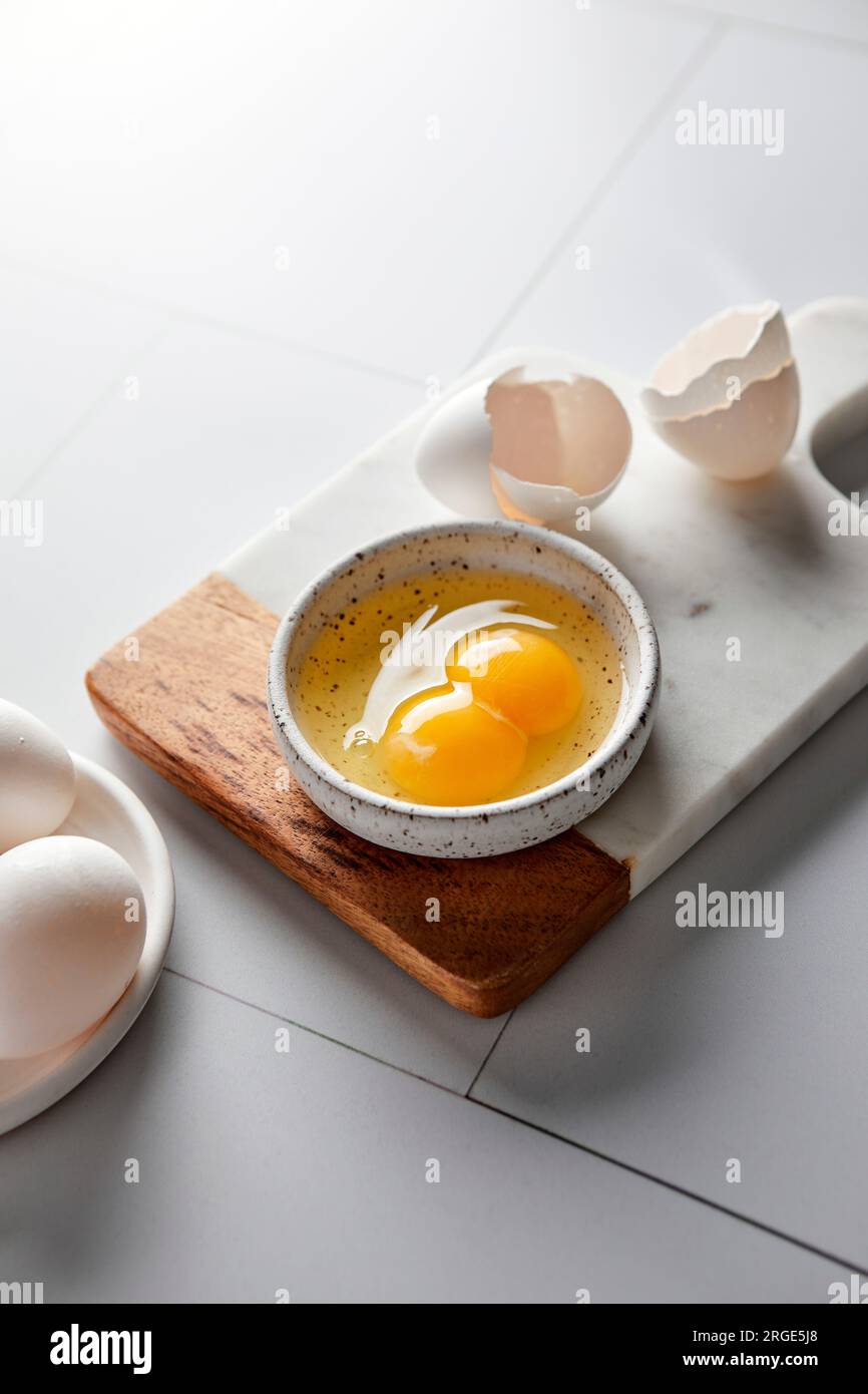 Uovo con doppio tuorlo incrinato in un recipiente piccolo Foto Stock