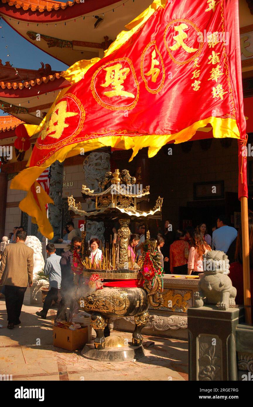 Una bandiera ornata ondeggia nella brezza durante una celebrazione del Capodanno lunare in un tempio buddista il capodanno cinese Foto Stock