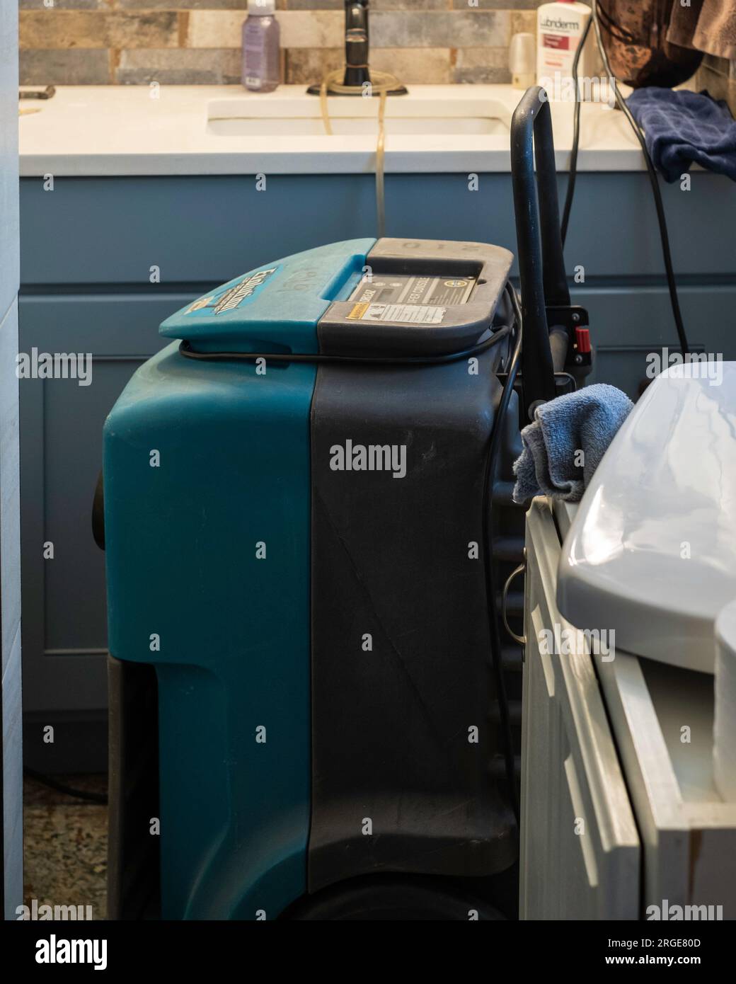 Un deumidificatore industriale che lavora nel bagno di una casa con una grande perdita d'acqua. USA. Foto Stock