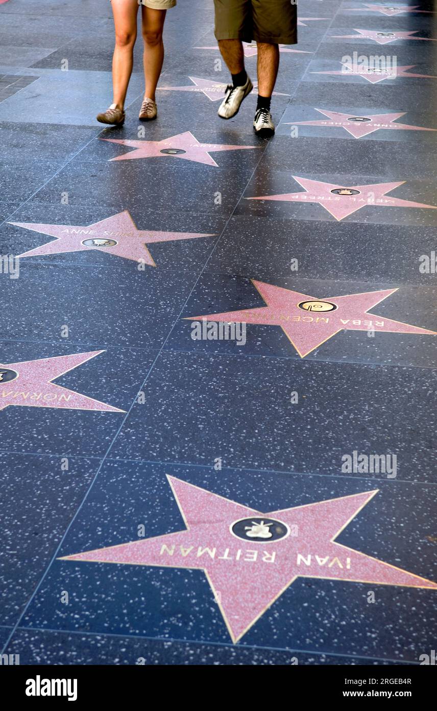 I visitatori che camminano sulla storica Walk of Fame su Hollywood Blvd. A Los Angeles, CALIFORNIA, USA Foto Stock