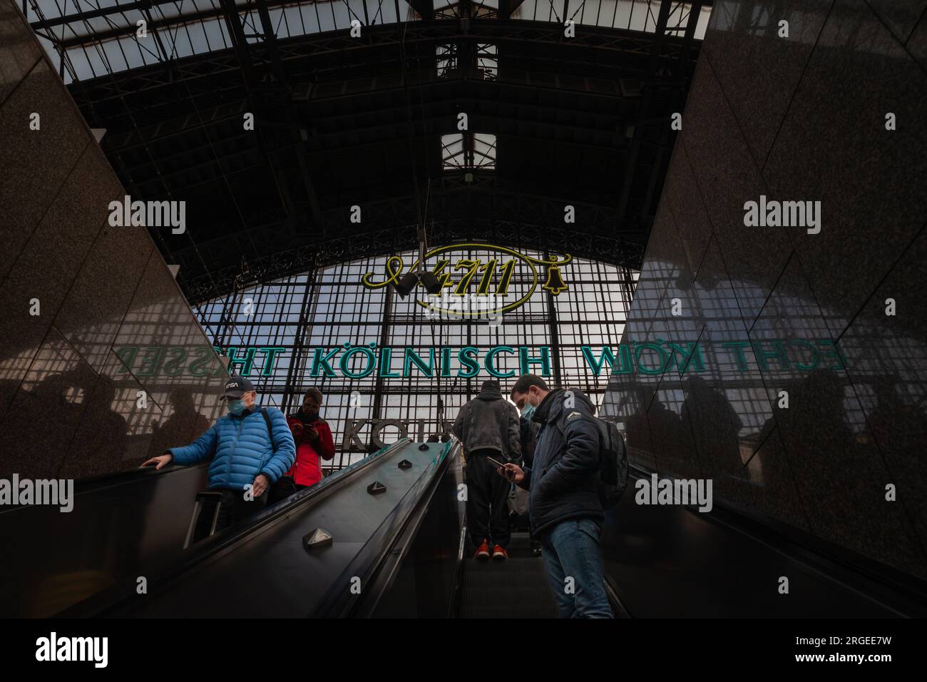 Immagine di un uomo in attesa di un treno sulle piattaforme della stazione ferroviaria di Colonia Koln hauptbahnhof, indossando maschere facciali durante il Coronavirus Covid 19 h. Foto Stock
