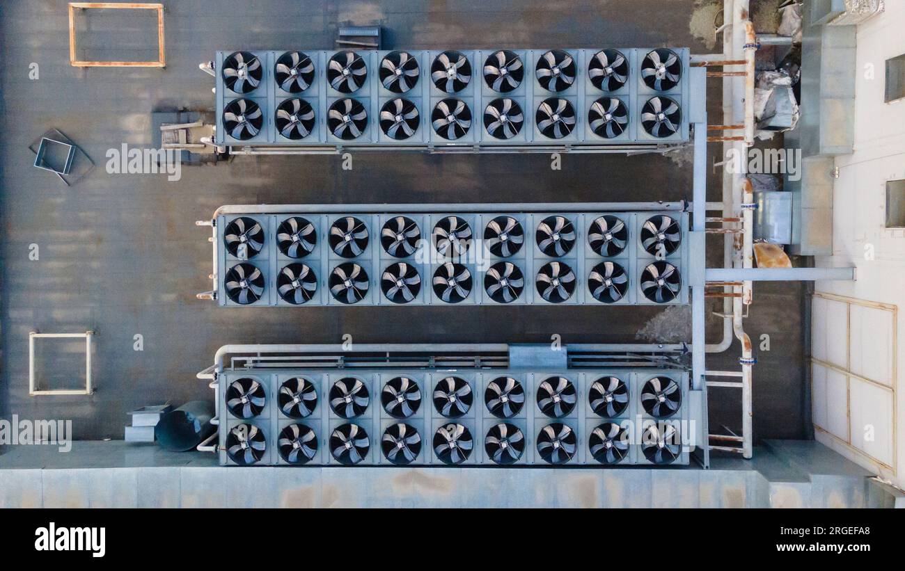 Tre file di ventilatori a spirale sul tetto di un edificio. Vista droni Foto Stock