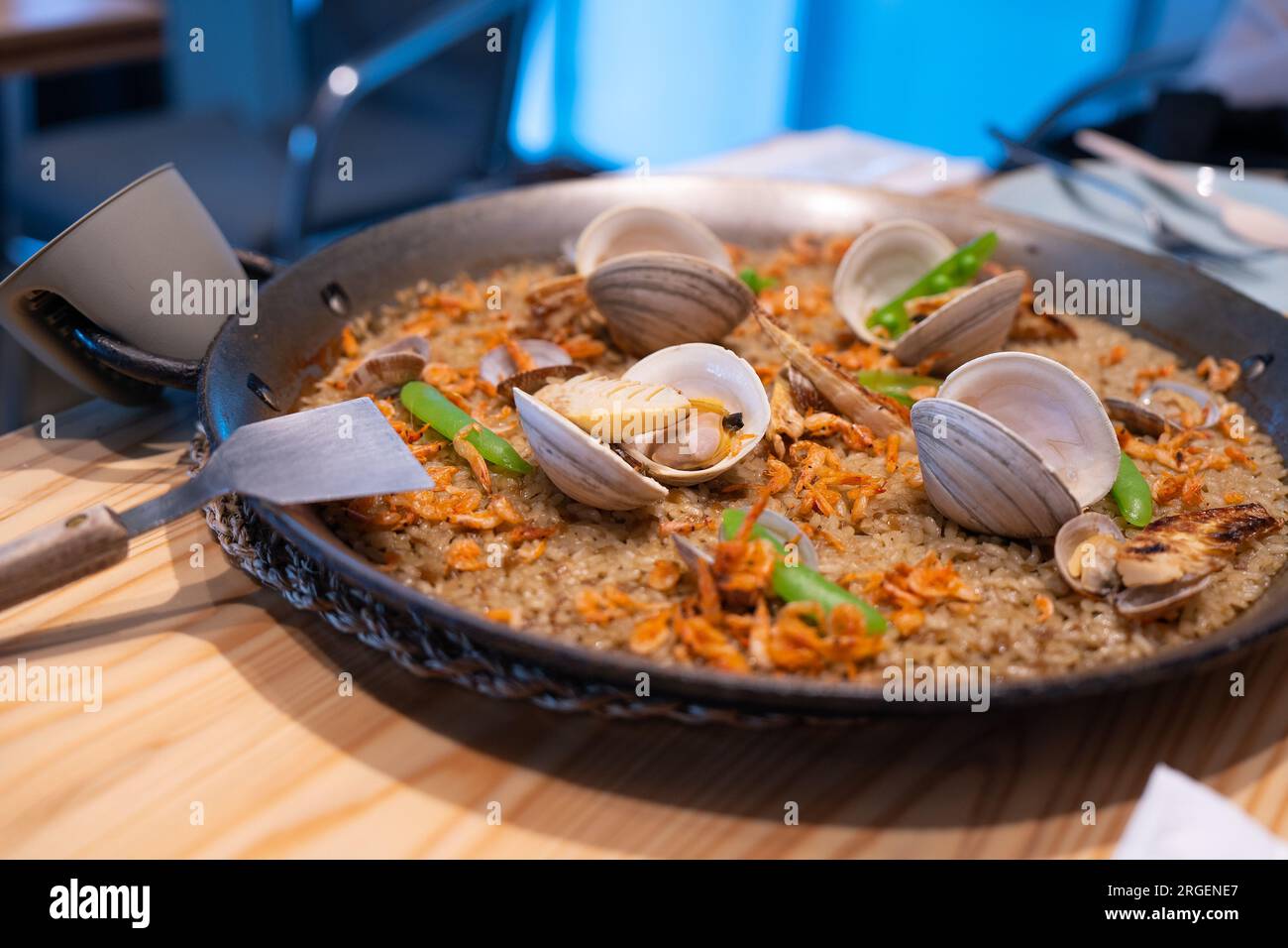 Paella tradizionale cucina spagnola, paella di pesce in paella fritta con vongole, gamberi e fagioli verdi. Foto Stock