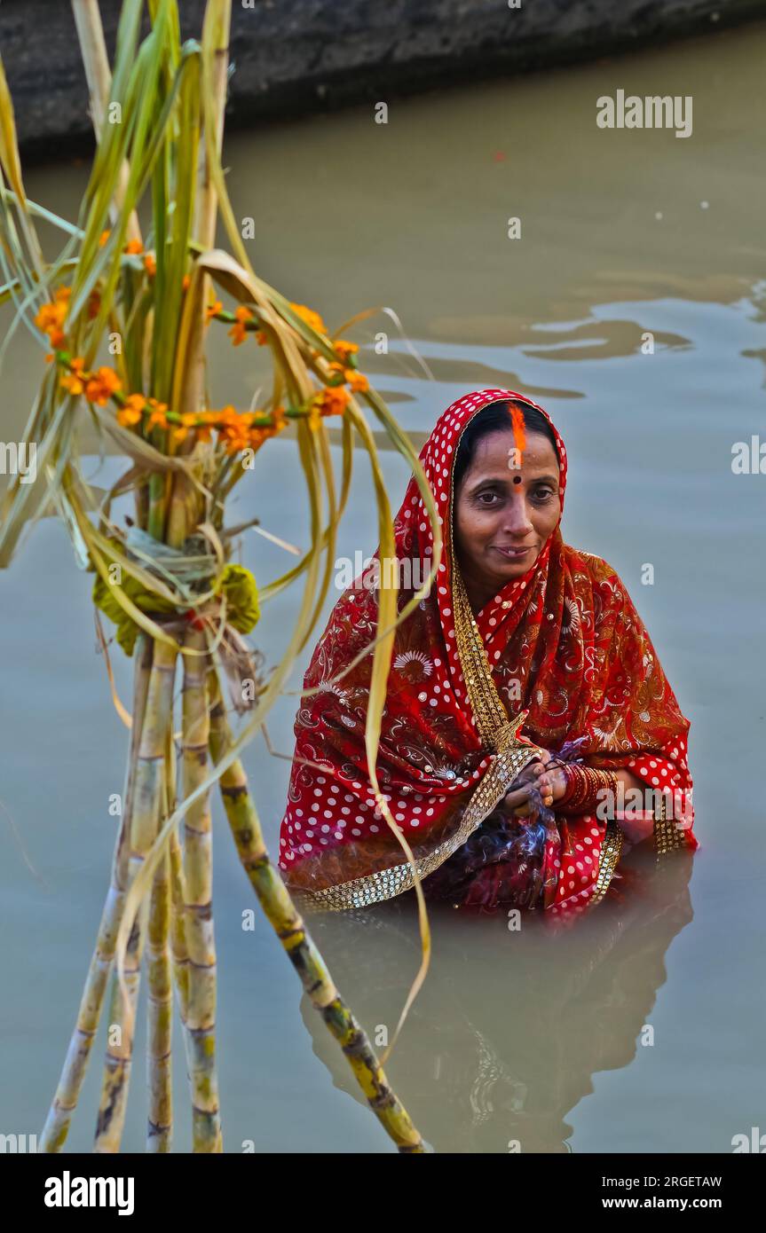India Woman in piedi nel fiume santo Gange, che offre preghiere per il tramonto e il sorgere del sole durante Chhath - Hindu Festival, Varanasi Foto Stock