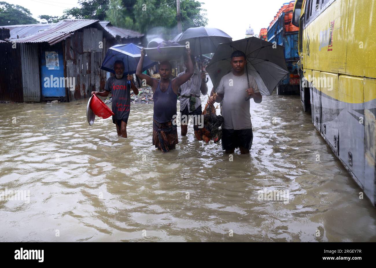 Chattogram. 9 agosto 2023. I pedoni attraversano una strada allagata a Chattogram, Bangladesh, l'8 agosto 2023. Giorni di piogge torrenziali hanno devastato la città portuale del Bangladesh, Chattogram, a circa 242 km a sud-est della capitale Dhaka, inondando aree basse e disturbando il traffico stradale con il più alto downpour finora registrato quest'anno lunedì.strade, le corsie e le corsie in alcune parti della principale città portuale del paese sono andate sotto le caviglie fino ad acqua profonda al ginocchio, causando enormi difficoltà ai pendolari e ai suoi milioni di abitanti. Crediti: Xinhua/Alamy Live News Foto Stock