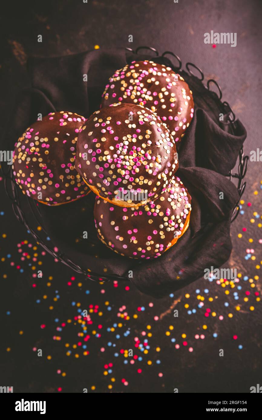 Ciambelle berlinesi, ripiene di marmellata e coriandoli colorati Foto Stock