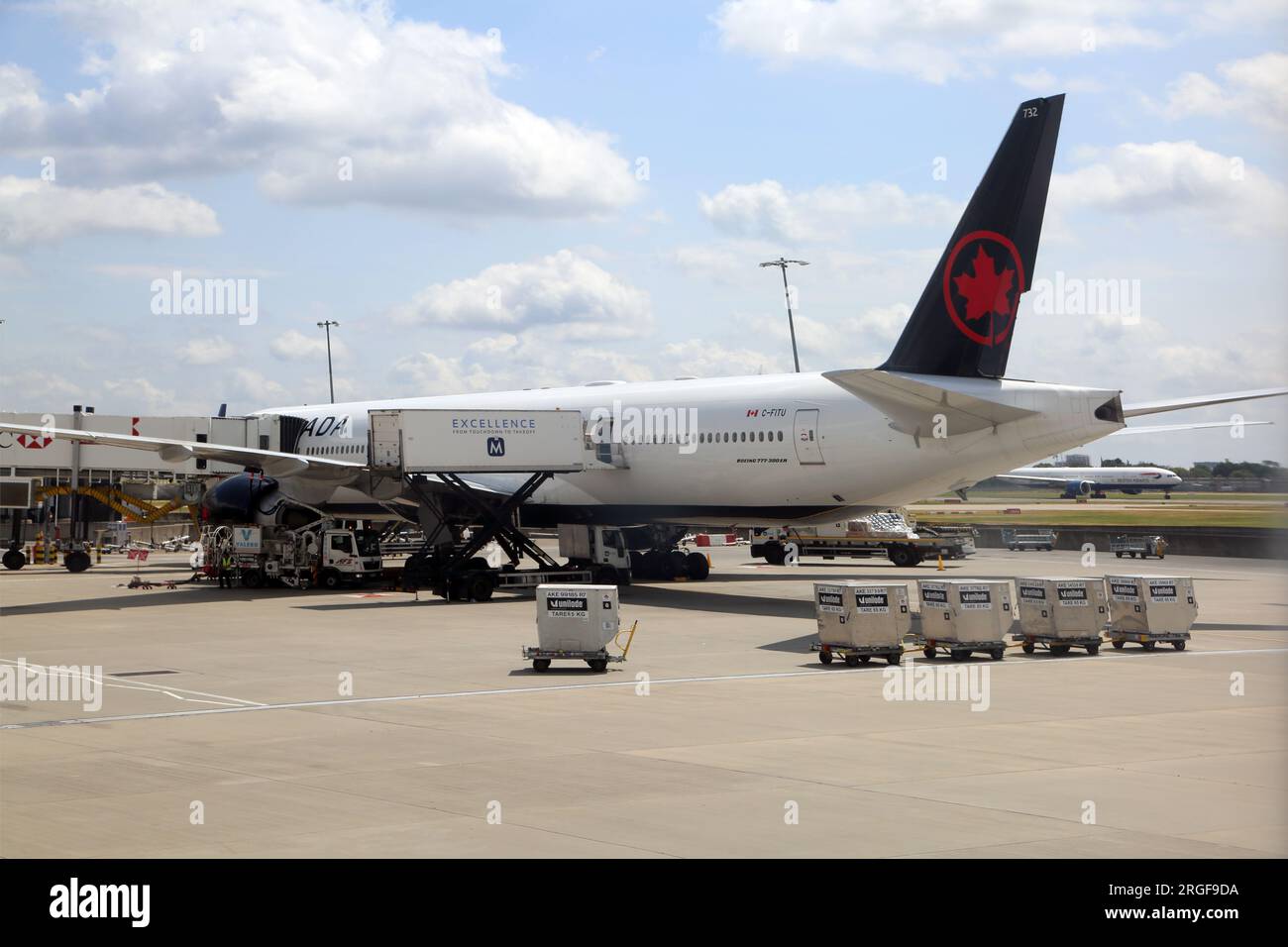 Furgone catering che carica Canada Airlines Boeing 777-300ER con Jet Bridge collegato all'aeroporto di Heathrow Terminal 2 Londra Inghilterra Foto Stock