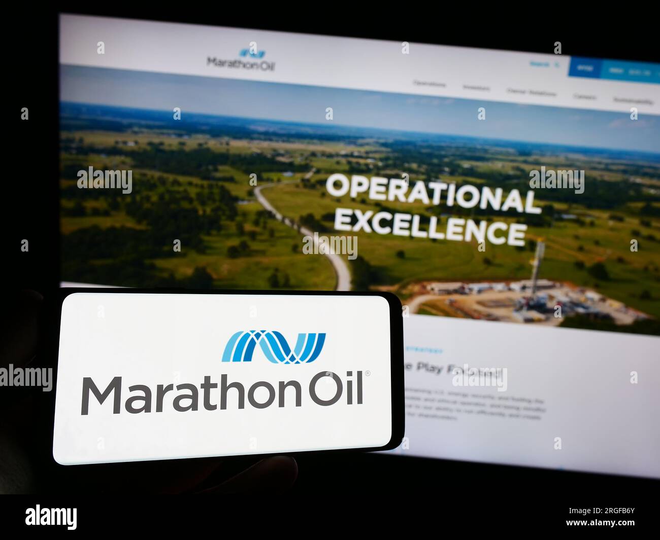 Persona che possiede uno smartphone con il logo della società petrolifera statunitense Marathon Oil Corporation sullo schermo di fronte al sito Web. Concentrarsi sul display del telefono. Foto Stock