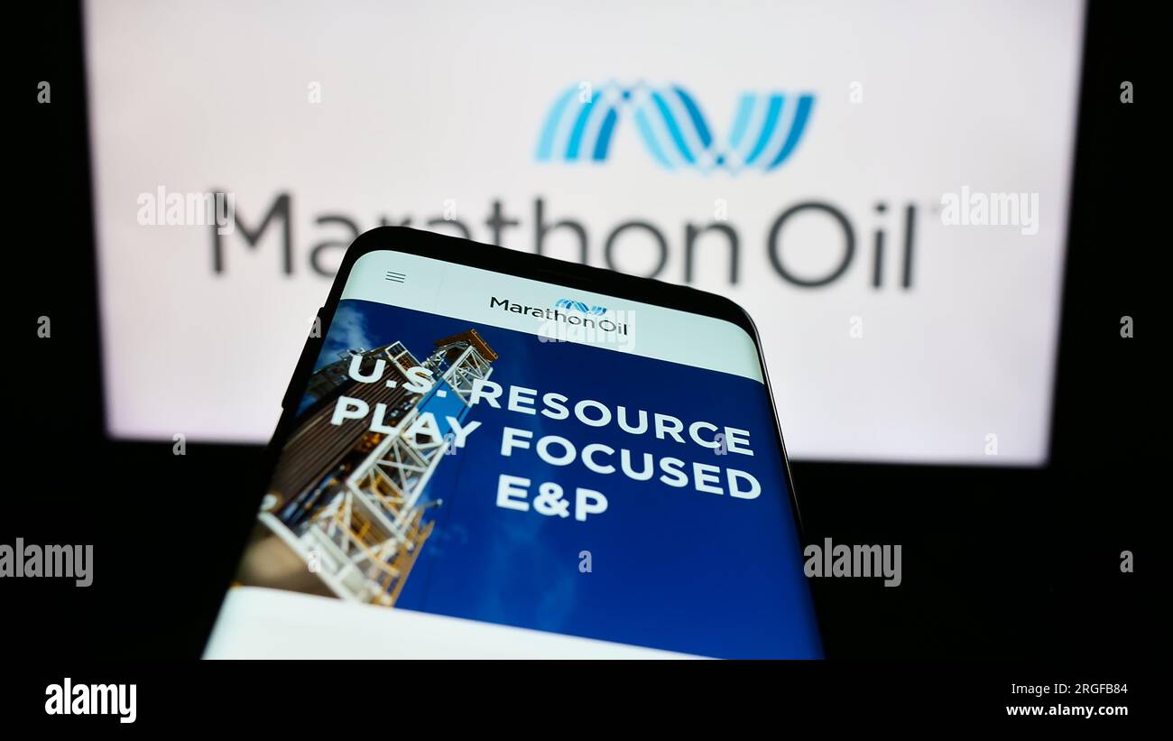 Telefono cellulare con pagina Web della società petrolifera statunitense Marathon Oil Corporation sullo schermo davanti al logo. Mettere a fuoco in alto a sinistra sul display del telefono. Foto Stock