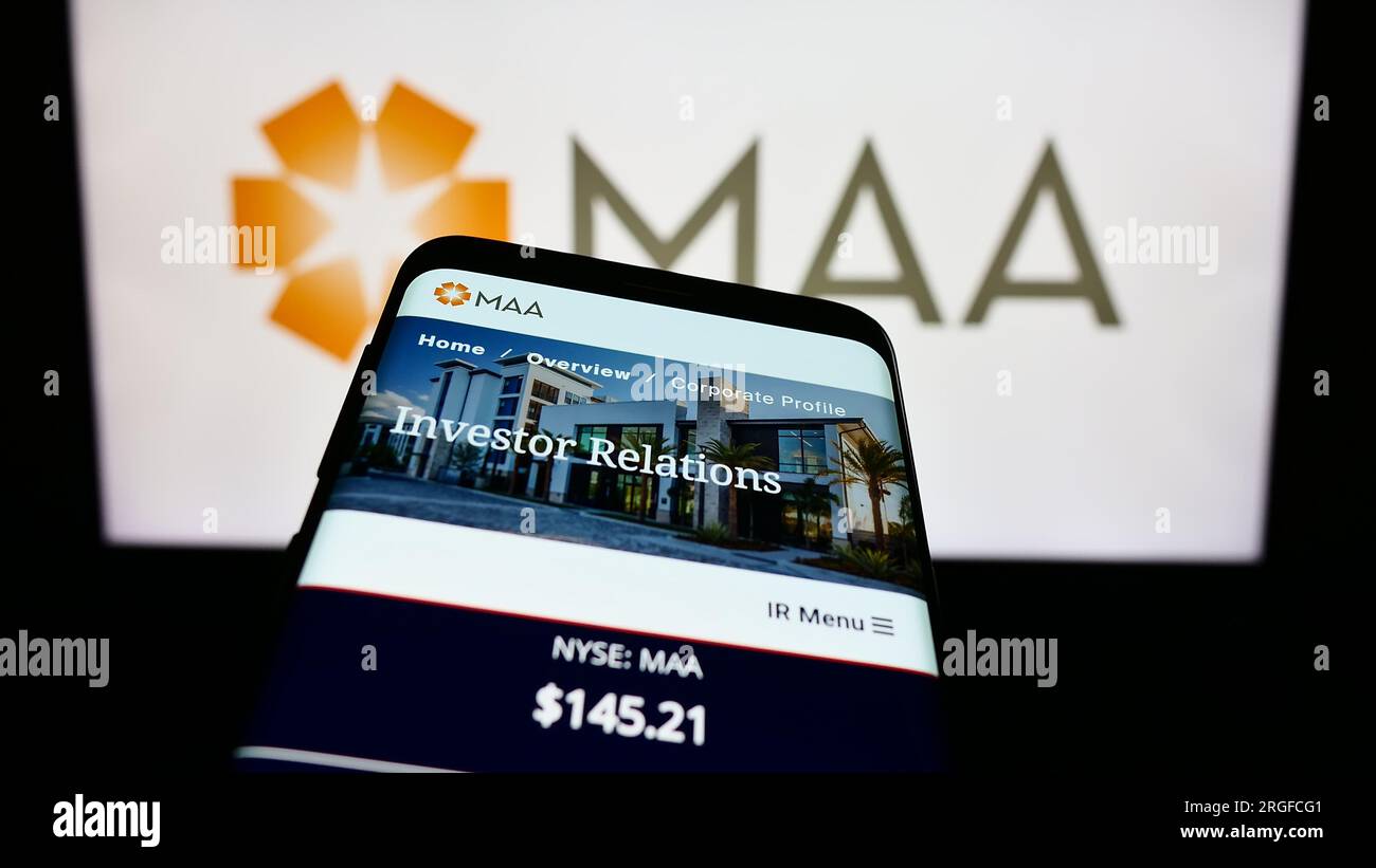 Telefono cellulare con sito Web di Mid-America Apartment Communities Inc (MAA) sullo schermo davanti al logo. Mettere a fuoco in alto a sinistra sul display del telefono. Foto Stock