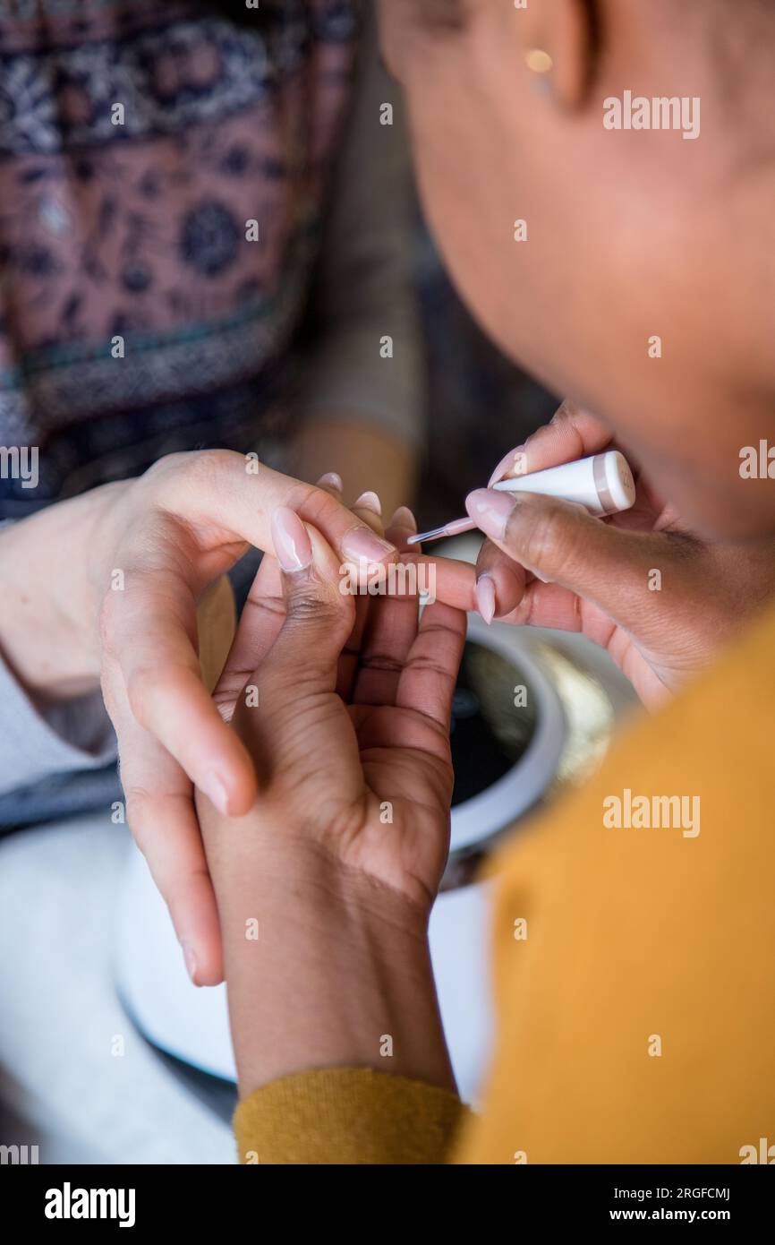 Donna che si prende cura delle unghie con un servizio di manicure. Mani di una persona con una manicure. Fasi del processo Foto Stock