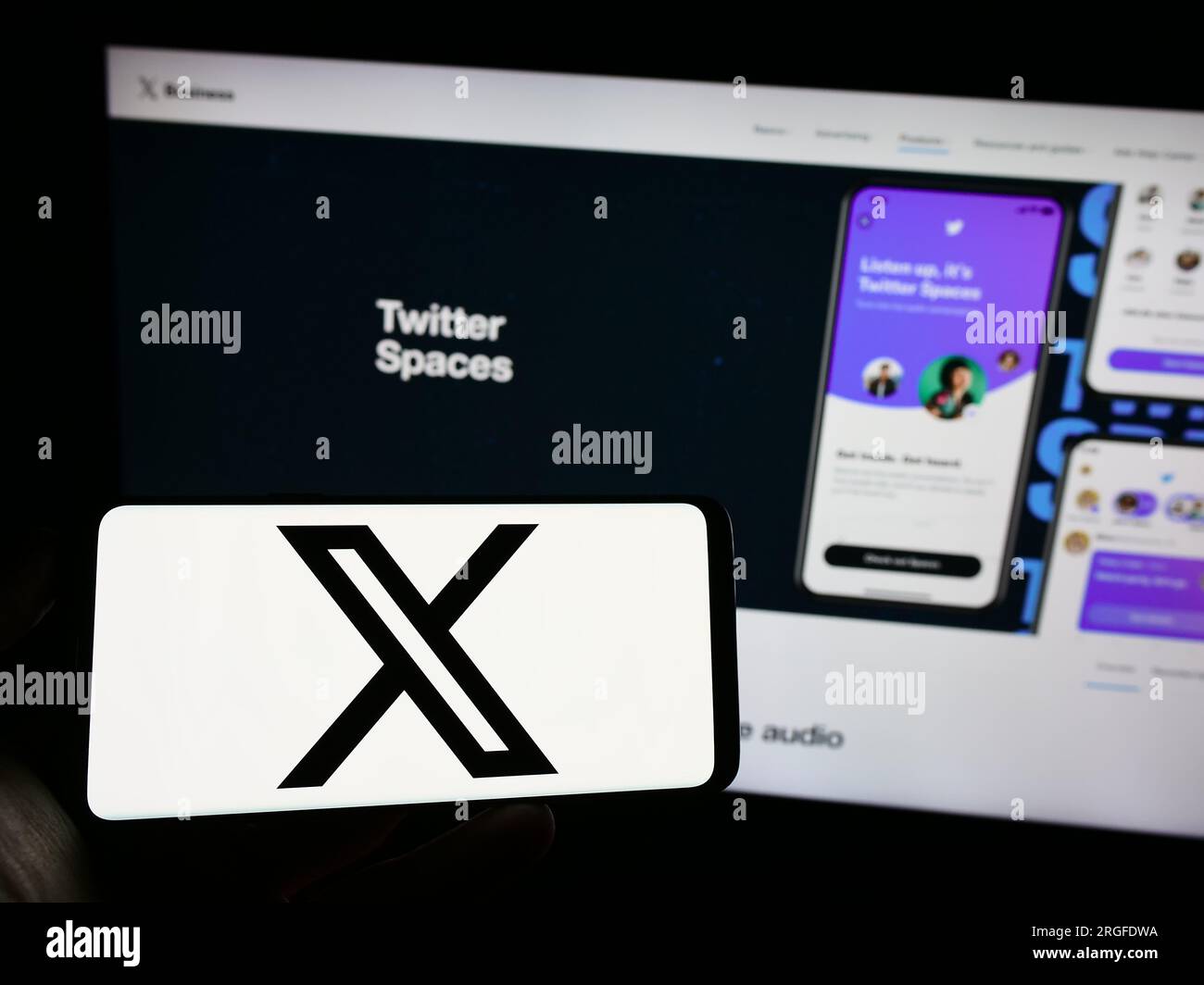 Persona che possiede un telefono cellulare con il logo della società americana di social media X Corp. (Twitter) sullo schermo davanti alla pagina Web. Concentrarsi sul display del telefono. Foto Stock