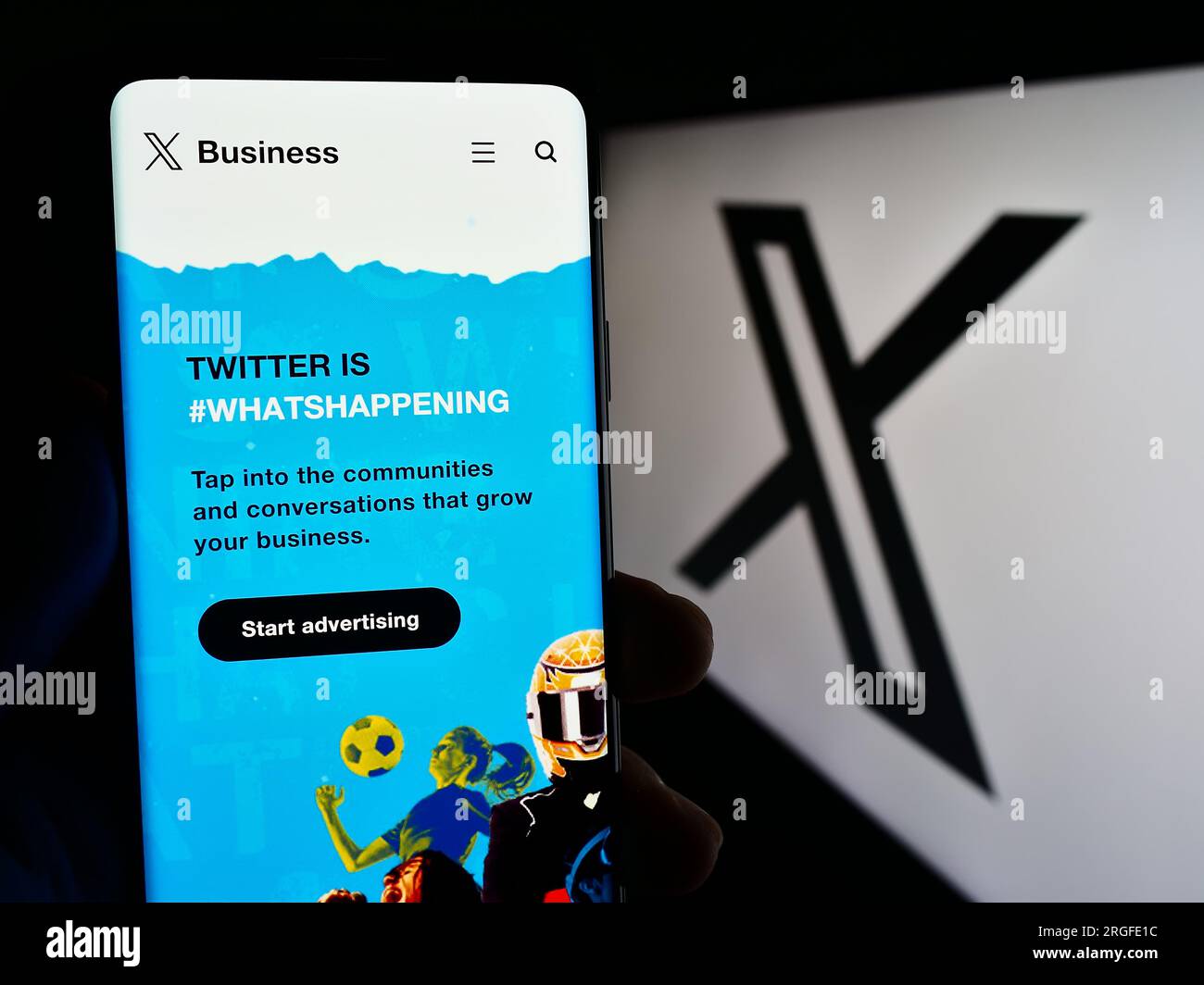Persona in possesso di cellulare con pagina web della società di social media statunitense X Corp. (Twitter) sullo schermo davanti al logo. Concentrarsi sul centro del display del telefono. Foto Stock