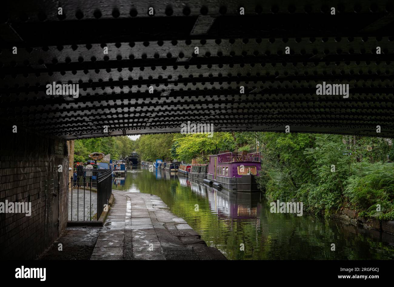 Londra, Regno Unito: Case galleggianti a Blomberg Road Moorings sul Regent's Canal a Londra, parte dell'area conosciuta come Little Venice. Visto da sotto un ponte. Foto Stock
