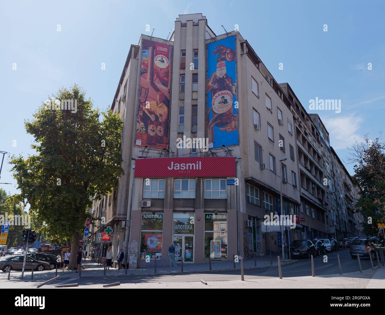 Edificio a più piani grigio con negozi con pubblicità illustrativa alla fine della città di Belgrado, Serbia. 9 agosto 2023. Foto Stock