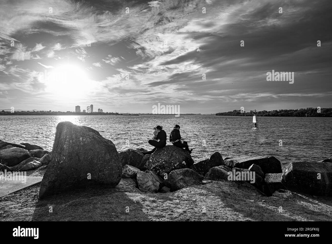 Due persone hanno appena finito di nuotare e riposarsi seduti sulla roccia Foto Stock