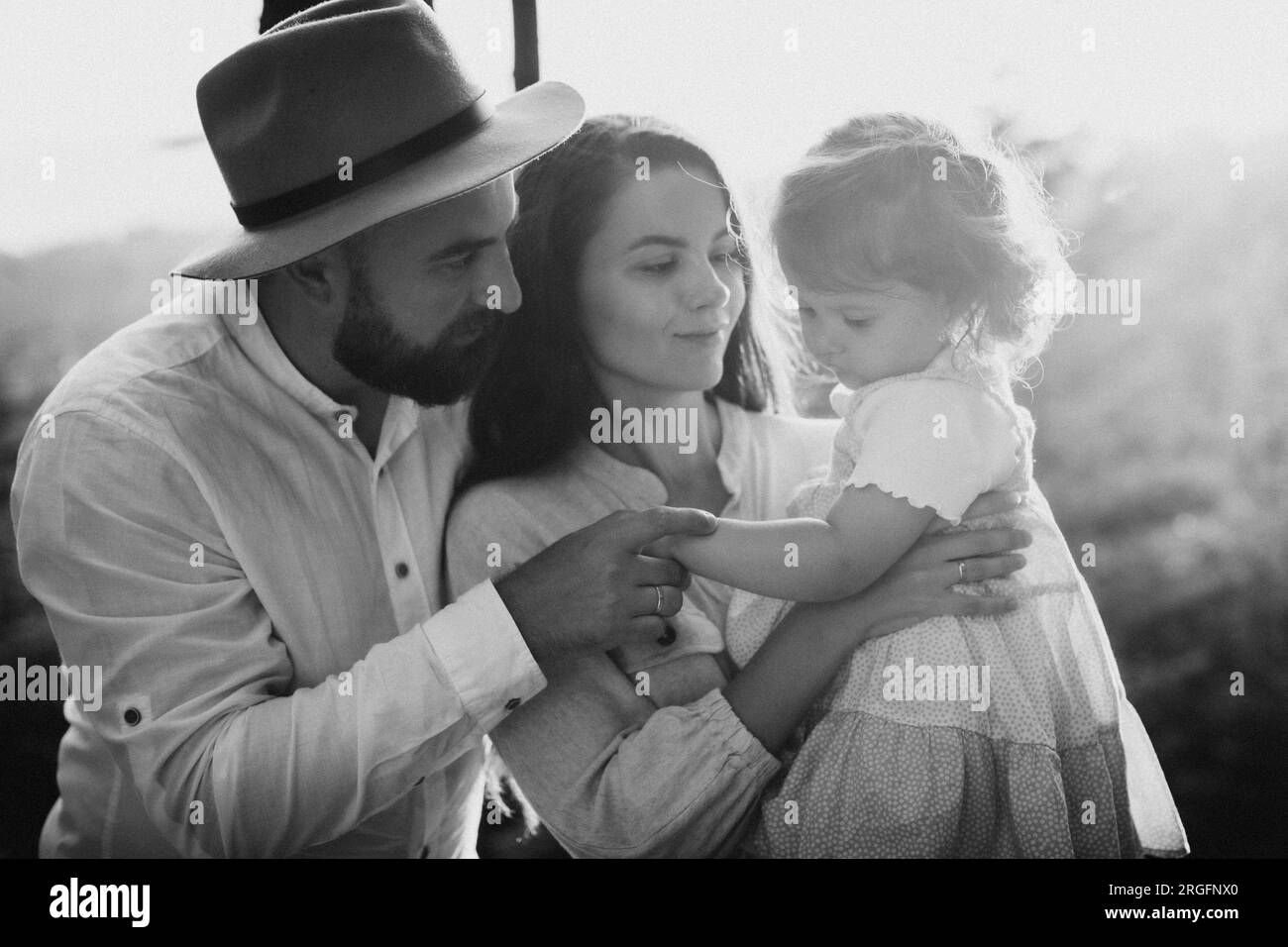 Famiglia felice con una figlia piccola all'aperto. Bianco e nero Foto Stock
