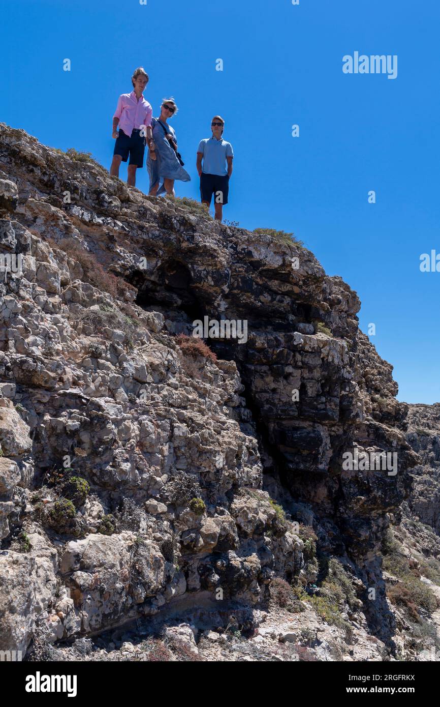 tre persone sulle rocce sopra il mare Foto Stock