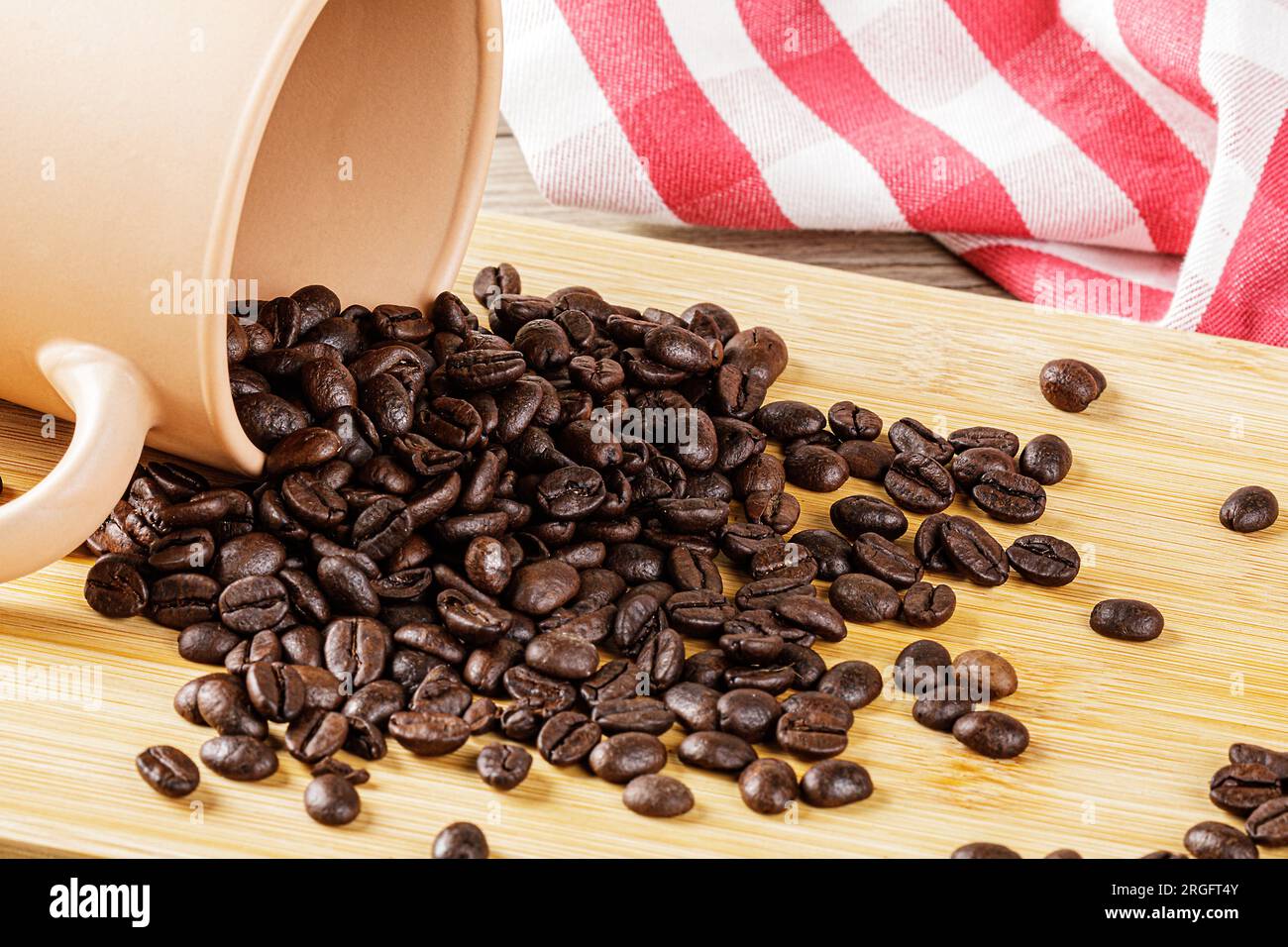 Primo piano dei deliziosi chicchi di caffè tostati su uno sfondo di legno con spazio per le copie Foto Stock
