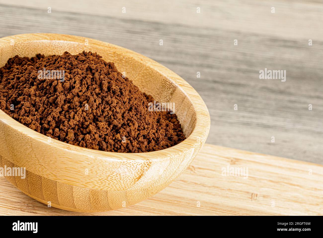 Ciotola in legno con fondi di caffè tostato macinati freschi su sfondo di legno con spazio per le copie Foto Stock