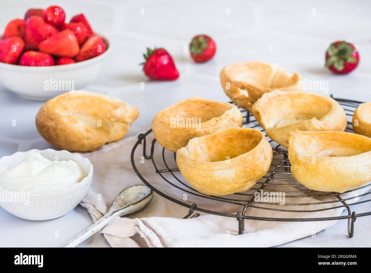 Panini di croissant fatti in casa da riempire con panna e fragole Foto Stock