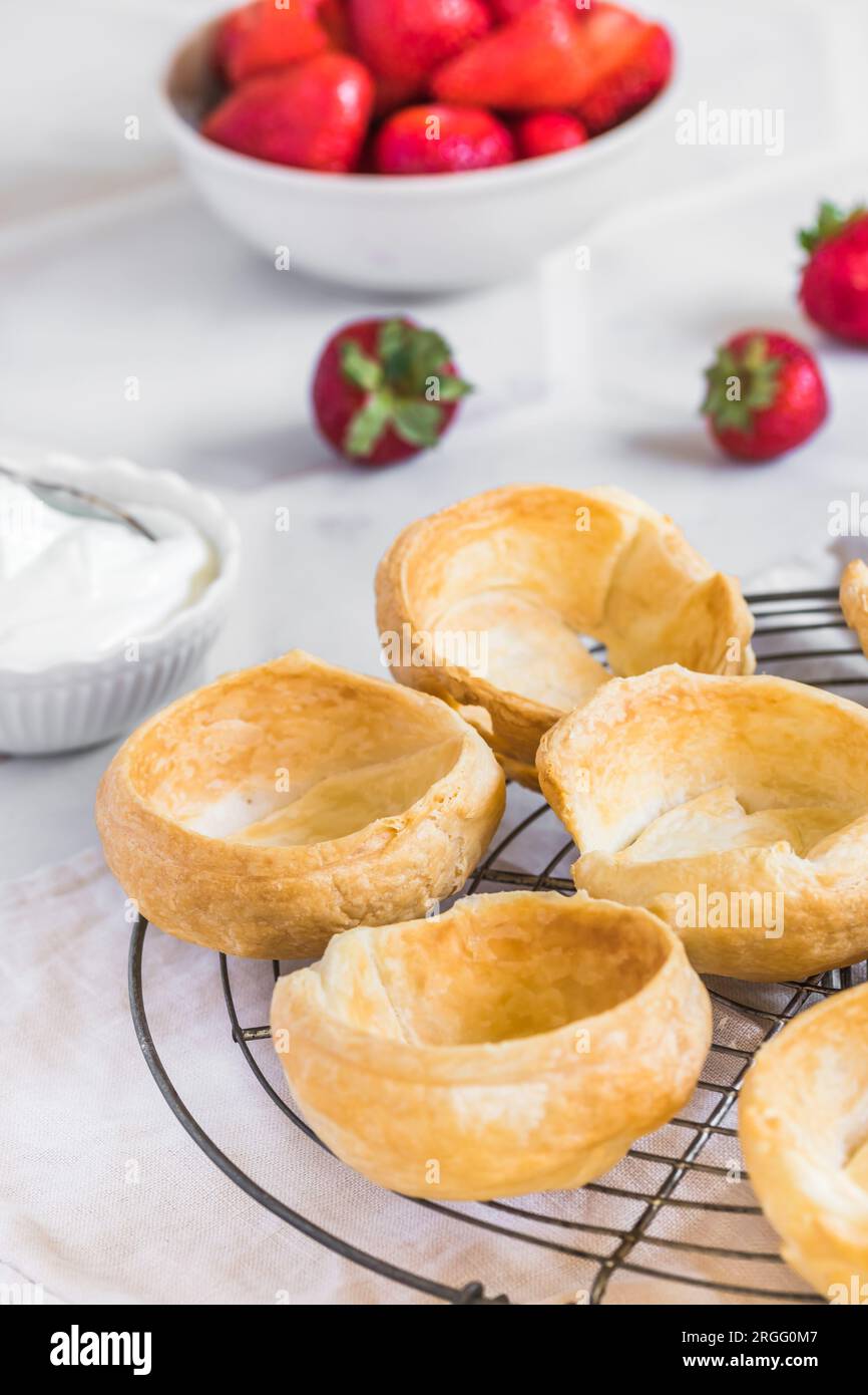 Panini di croissant fatti in casa da riempire con panna e fragole Foto Stock