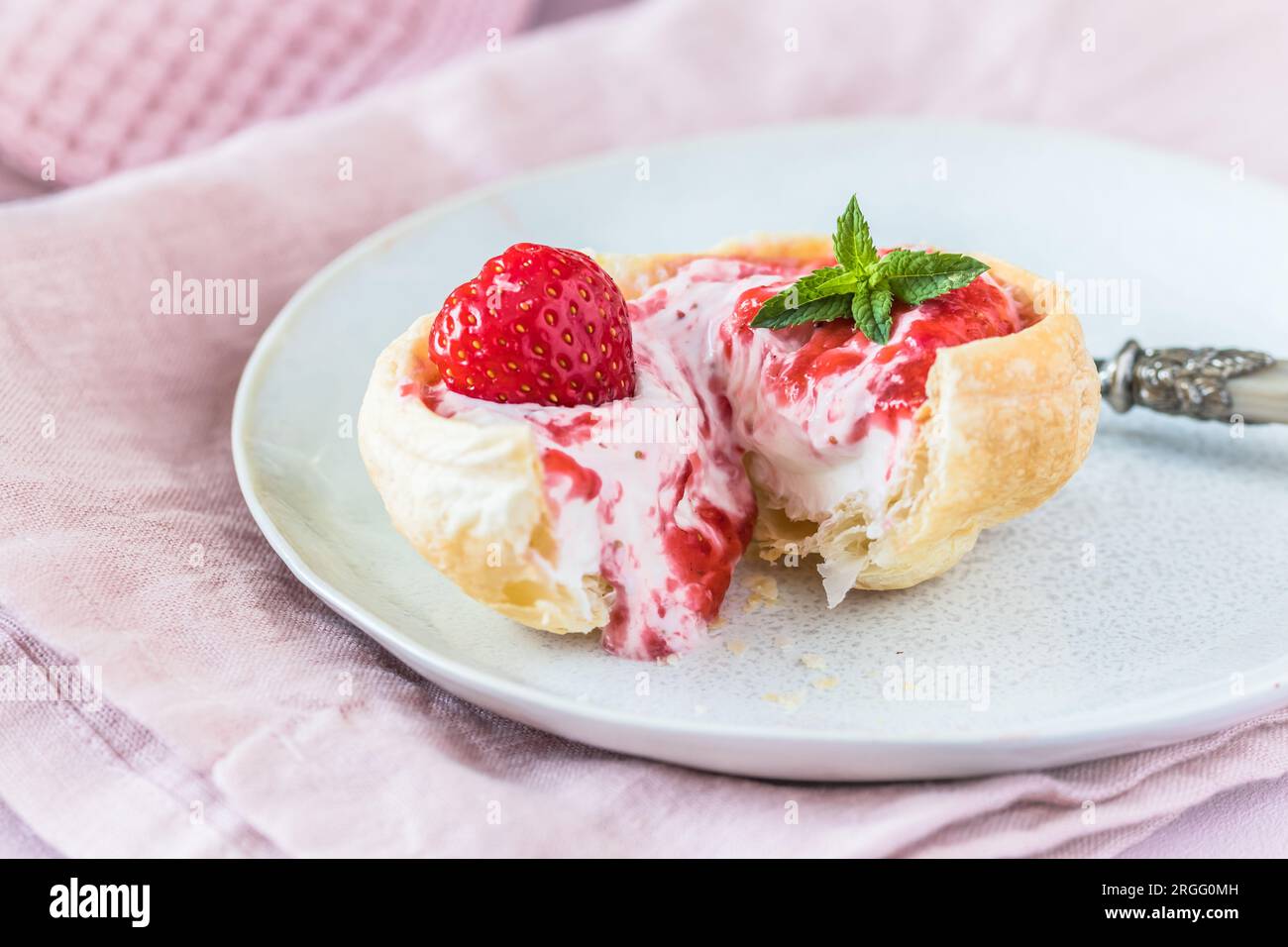 Panino con croissant fatto in casa ripieno di panna e purè di fragole Foto Stock