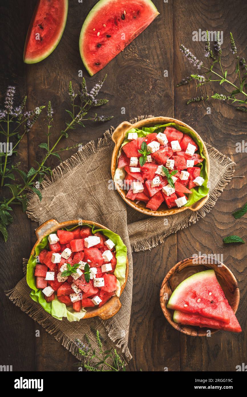 Insalata di anguria fresca con formaggio feta e menta su sfondo rustico in legno, vista dall'alto Foto Stock