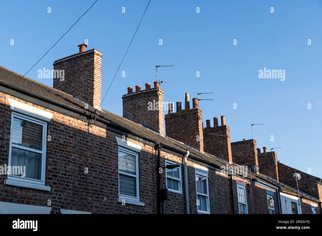 Una fila di case a schiera economiche da affittare e comprare per i primi acquirenti che rappresentano i costi abitativi con spazio di copia sopra Foto Stock