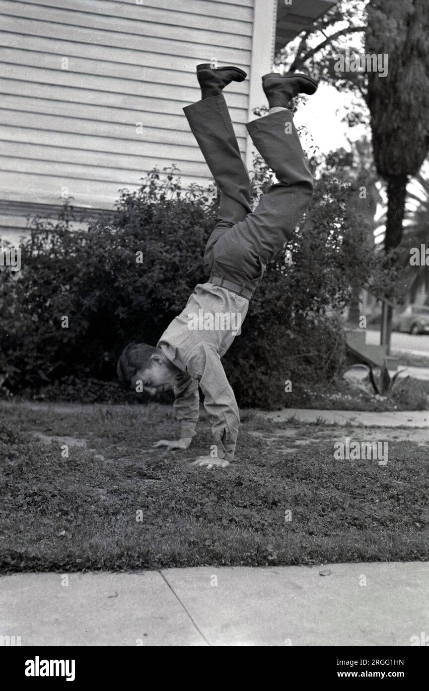 Anni '1940, storico, all'aperto in una zona residenziale di LOS ANGELES, un soldato americano che dimostra la sua idoneità con un palco, USA. Foto Stock