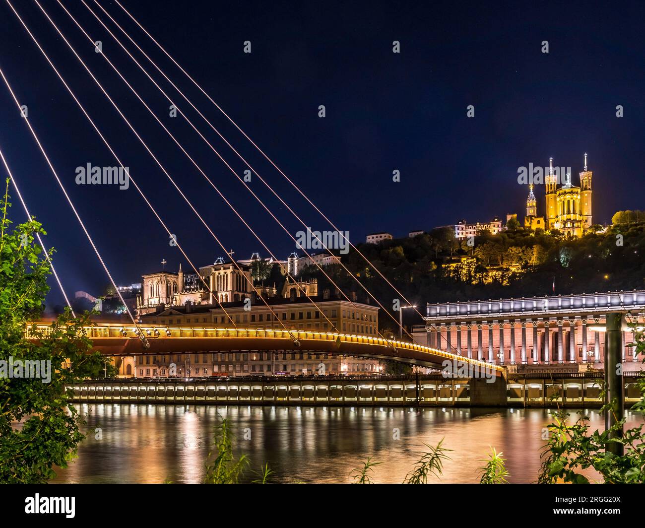 Vista notturna del ponte pedonale illuminato di Saint Georges, della Vieux Lyon e del fiume Saone a Lione, in Francia. Foto Stock