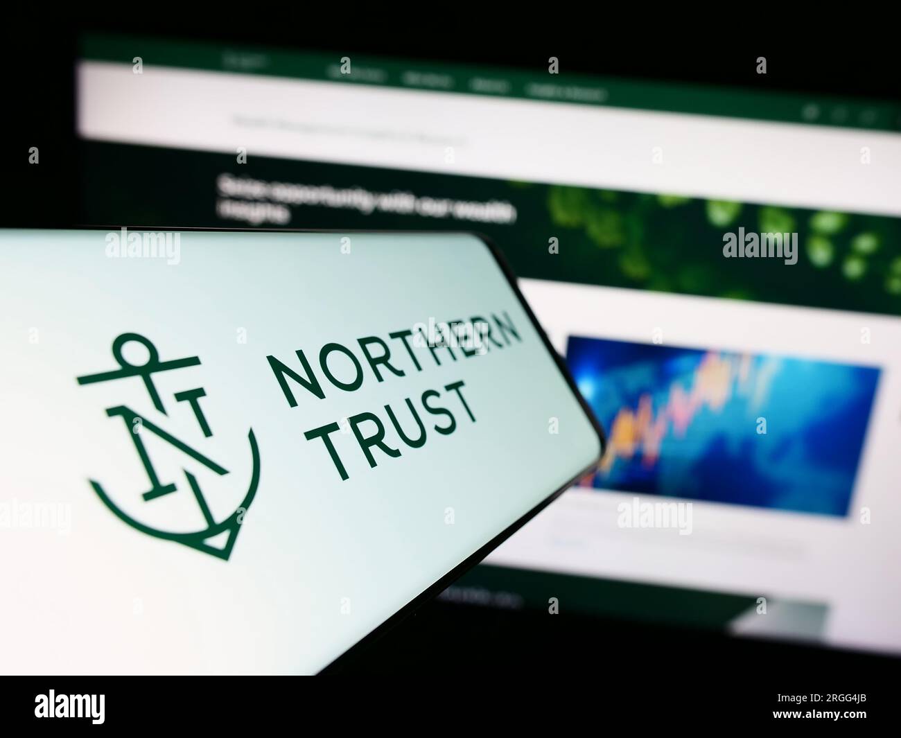 Smartphone con logo della società finanziaria statunitense Northern Trust Corporation sullo schermo davanti al sito Web. Mettere a fuoco il display centrale sinistro del telefono. Foto Stock