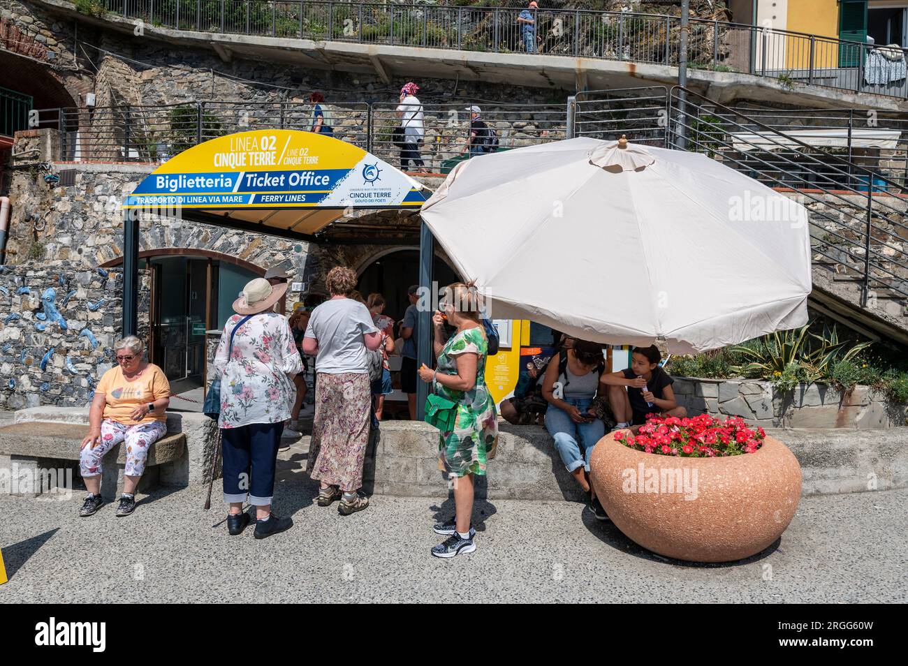 I turisti fanno la fila per acquistare brevi crociere in barca verso gli altri quattro porti sul lungomare di Monterosso al Mareone, uno dei piccoli vil da pesca appesi alla scogliera Foto Stock