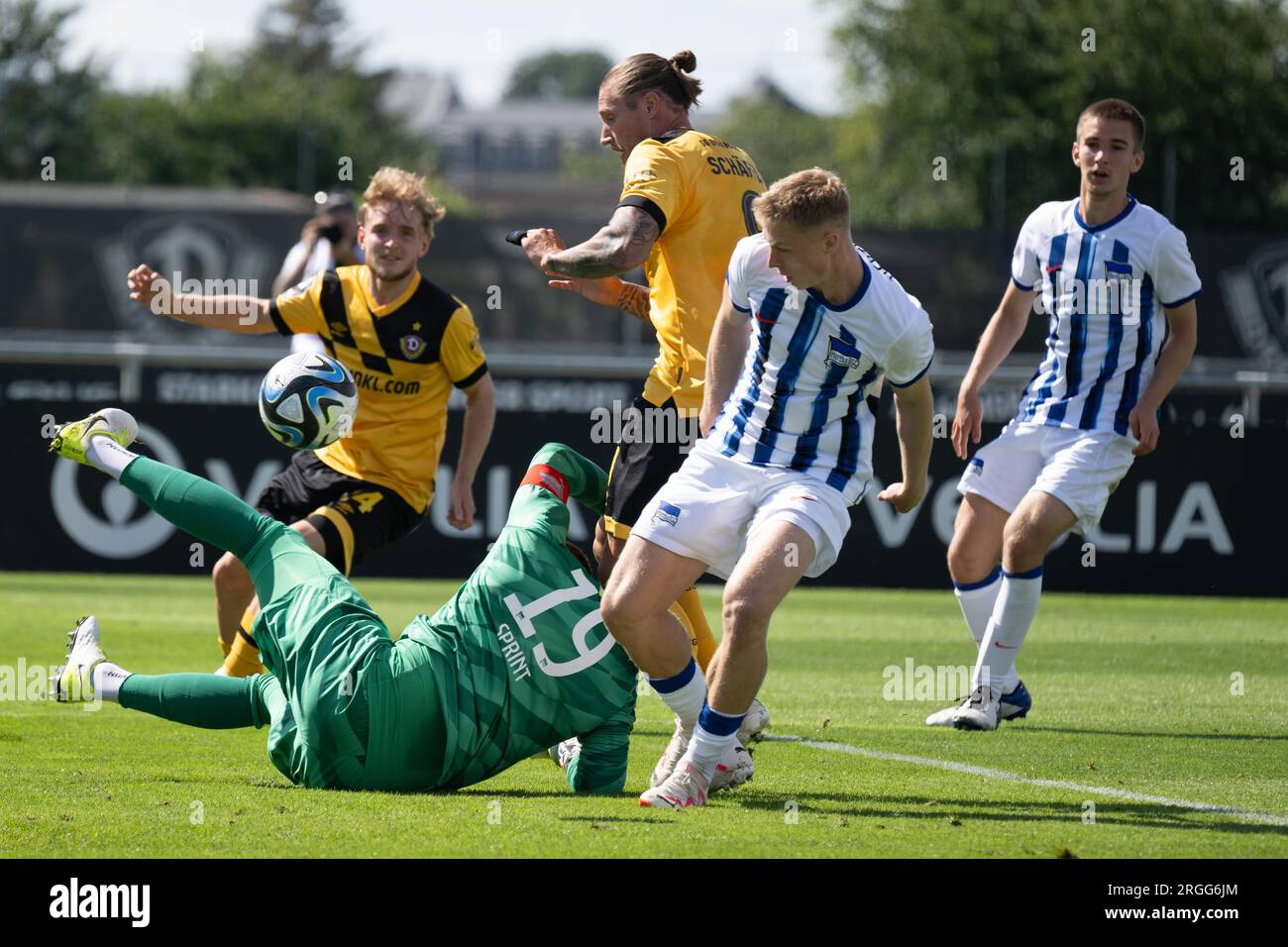 Dresda, Germania. 9 agosto 2023. Calcio: Test match, Dynamo Dresden - Hertha BSC II, all'AOK Plus Walter-Fritzsche-Akademie. Manuel Schäffler (M) della Dinamo segna contro il portiere di Hertha Philip Sprint (sotto) per 1:0. Credito: Sebastian Kahnert/dpa/Alamy Live News Foto Stock