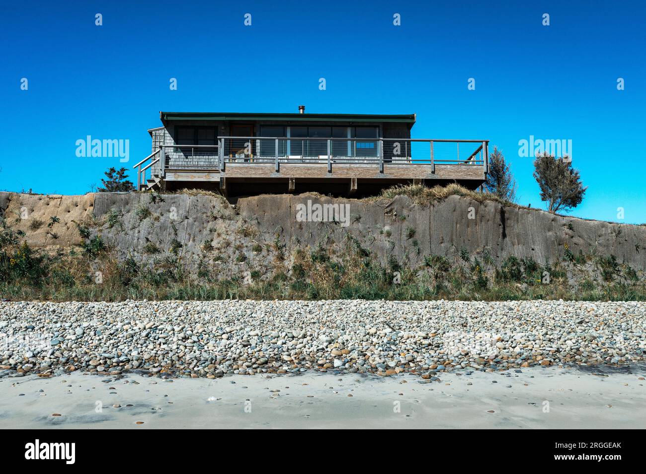 Casa sulla spiaggia minacciata dall'erosione costiera, Stonewall Beach Foto Stock