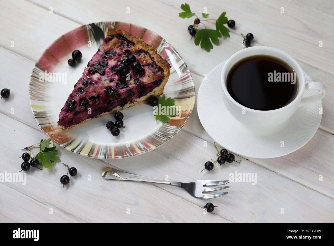 Torta al forno con frutti di bosco di stagione e tazza di caffè su sfondo di legno Foto Stock