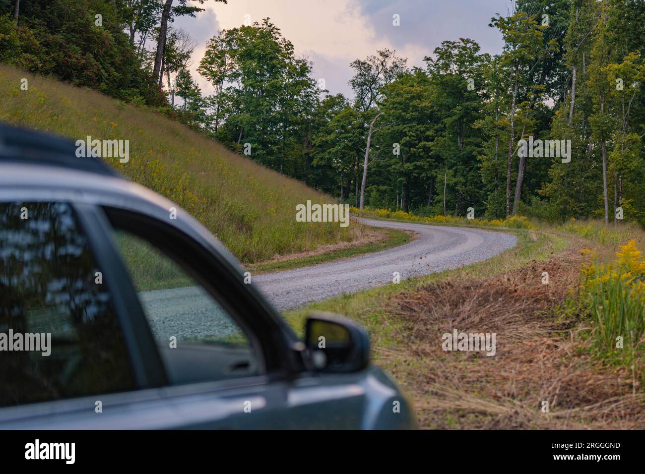 Auto al fianco del concetto di strada sterrata che rappresenta le attività di viaggio avventura escursionistica e vacanza Foto Stock