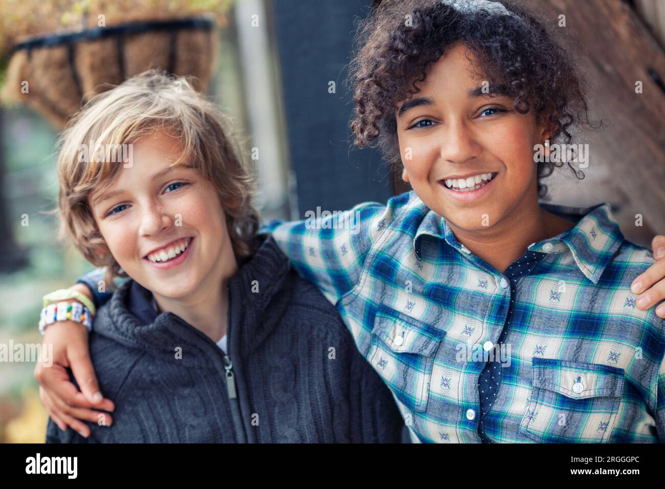 Gruppo etnico misto di due bambini felici, ragazza birazziale afroamericana ragazzo caucasico che ride insieme Foto Stock