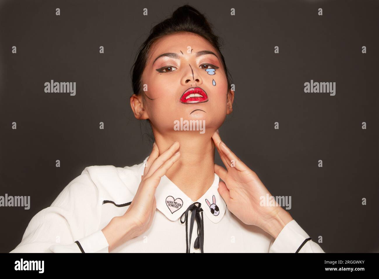 Giovane donna con il viso lacrime di vernice e linee Foto Stock