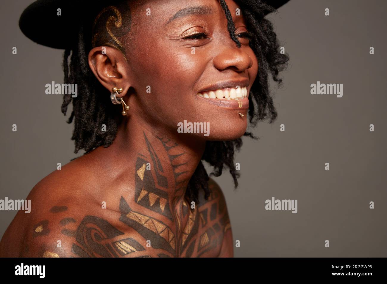 Sorridente giovane donna con tatuaggi Foto Stock