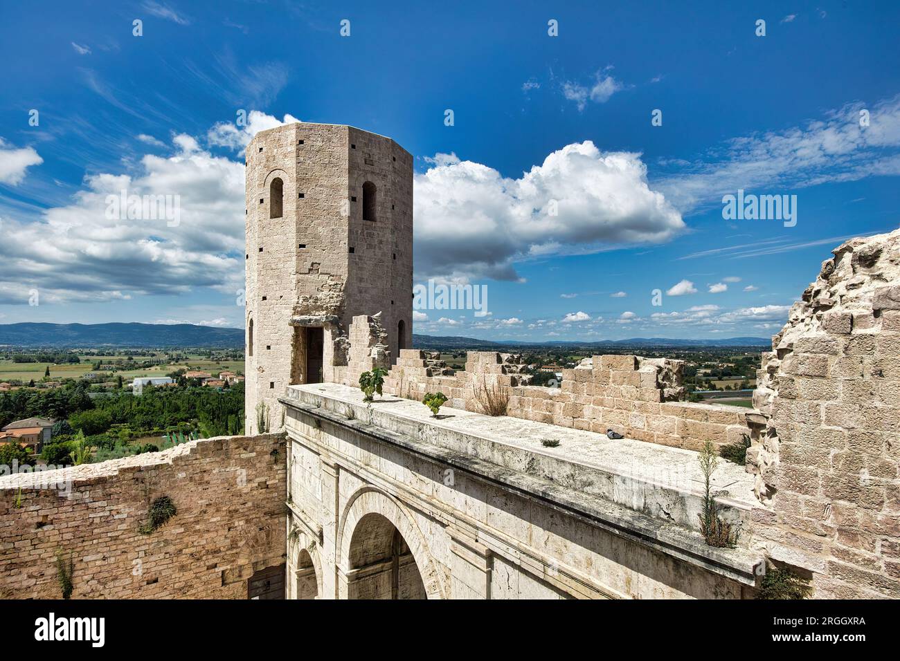 Città di Spello, Umbria, Italia. Di origine romana, porta Venere è così chiamata perché vicino al Tempio di Venere. Le pietre bianche risaltano contro un cielo blu. Foto Stock