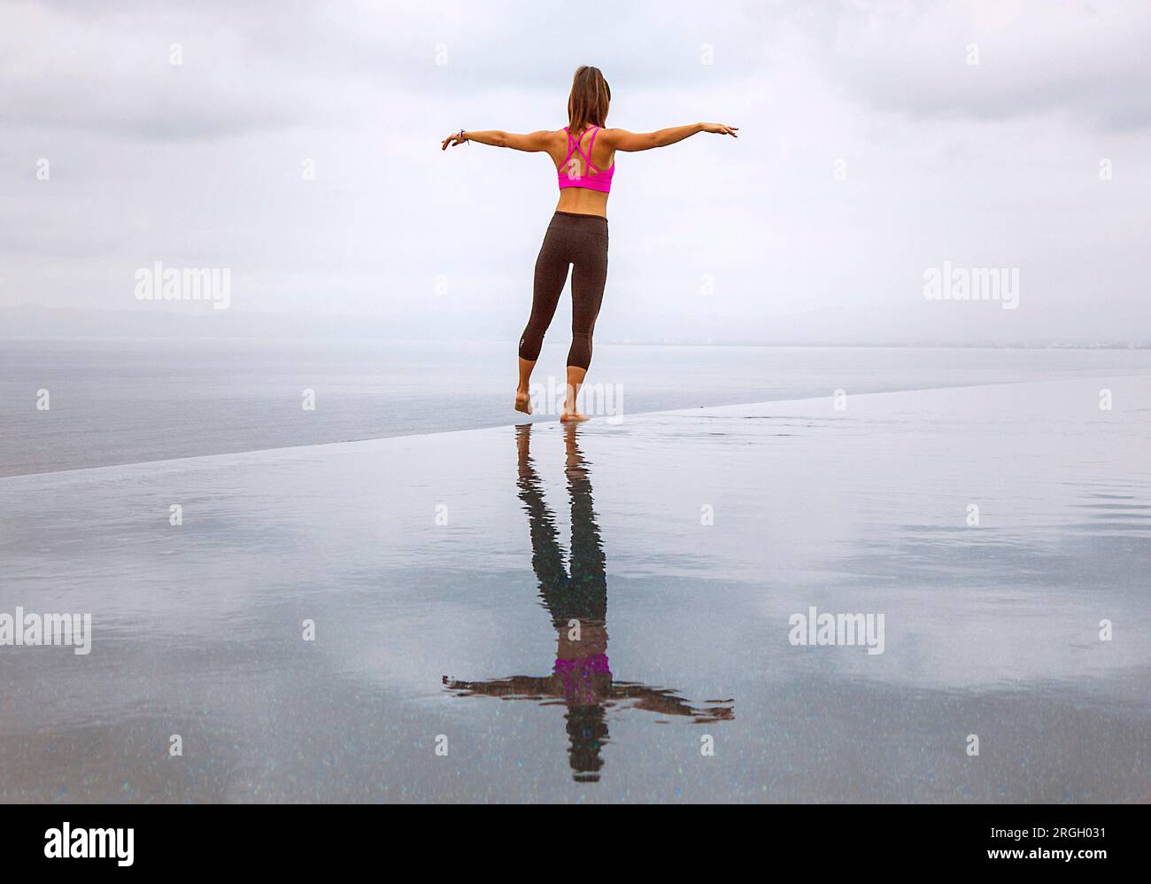 Donna in piedi con le braccia allungate dal mare Foto Stock