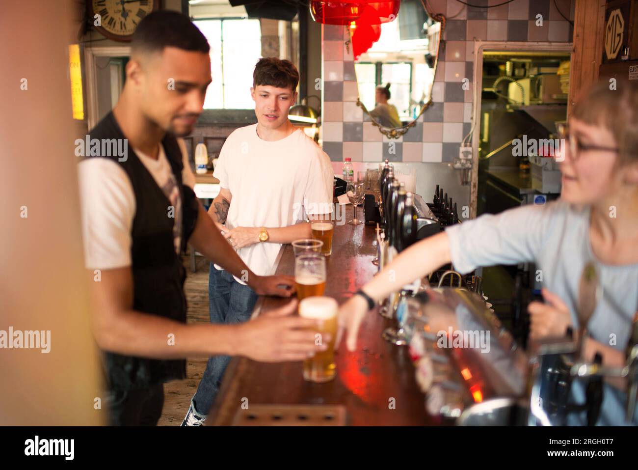 Barista che serve birra a un cliente in un bar Foto Stock