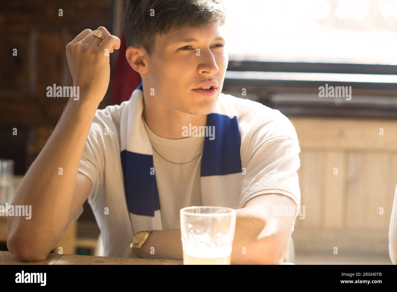 Giovane seduto con una pinta di birra. Foto Stock