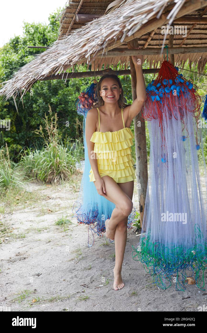 Giovane donna in beach hut con rete da pesca Foto Stock