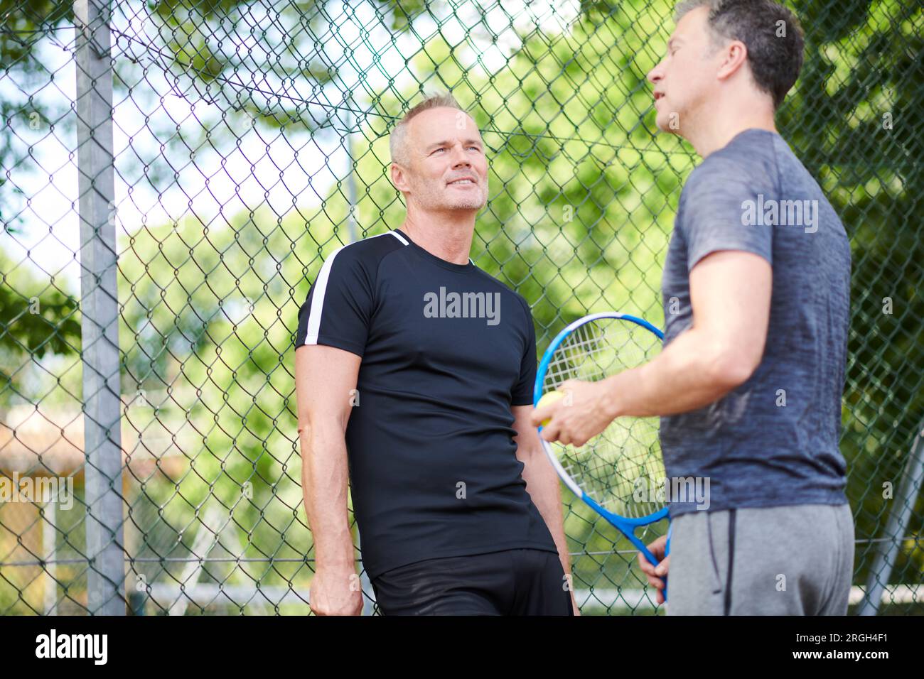 Uomini maturi sul campo da tennis Foto Stock